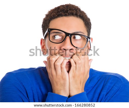 Closeup portrait of nervous, stressed young nerdy guy man in panic and fear, biting fingernails looking anxiously craving something isolated on white background. Negative emotion expression feeling