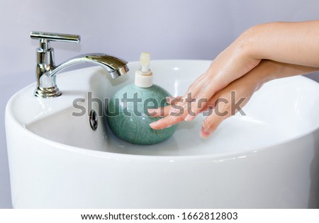 white round shape ceramic sinks and hands washing with liquid soap