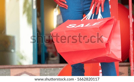 A red paper bag with a puppet in front of the store