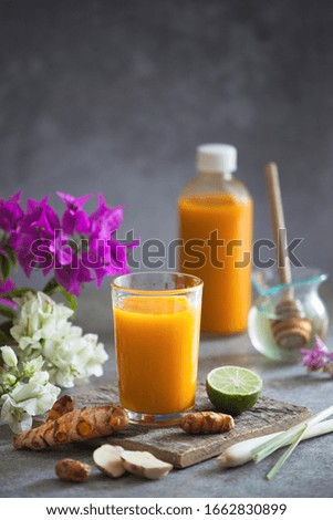Homemade healthy drink made of organic turmeric and style with some raw ingredients of ginger lemongrass lime and honey