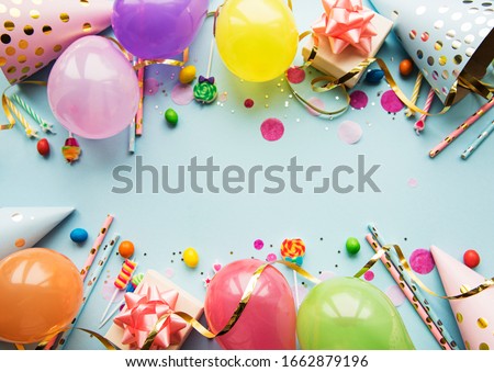 Happy birthday or party background.  Flat Lay wtih birthday balloons , confetti and ribbons on blue background. Top View.  Copy space.