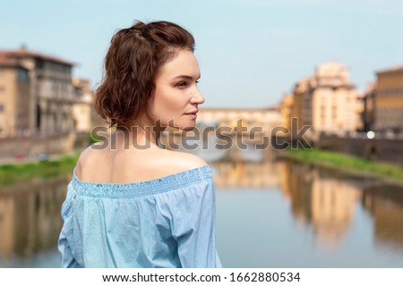 Portrait of a charming girl standing on a bridge in Florence. Arno River. View of the Ponte Vecchio. Tourism concept. Italy. Mixed media