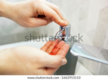 The woman is washing hands with soap in the bathroom