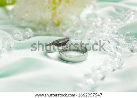 Beautiful wedding rings with necklace on cloth