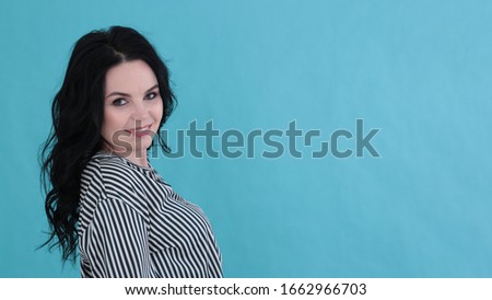 Portrait of a beautiful young woman with dyna black curly hair on a bright blue background