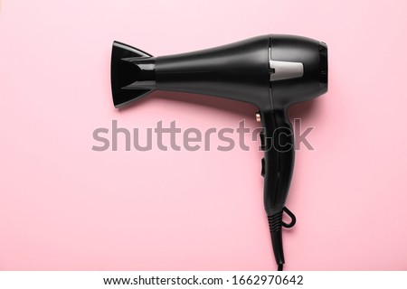 Modern hair dryer on color background Royalty-Free Stock Photo #1662970642