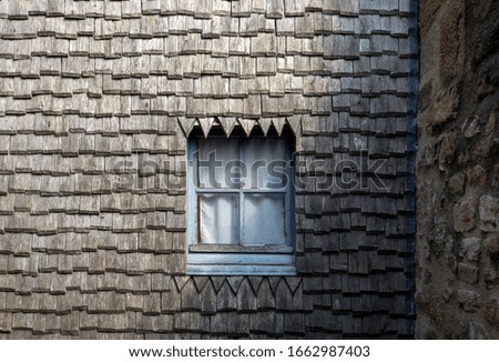 Small window in a shingle roof in Mont Saint-Michel, the monastery and village on a tidal island between Brittany and Normandy, France