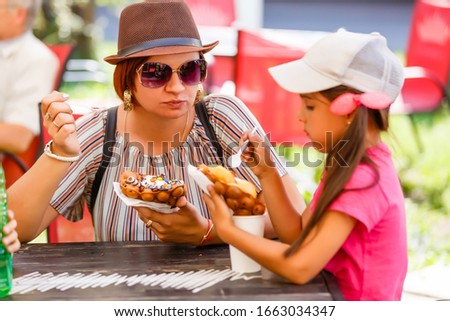 mother and children eating bubble waffle with ice cream