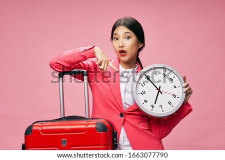 Pink background round clock and a woman with a suitcase in hand