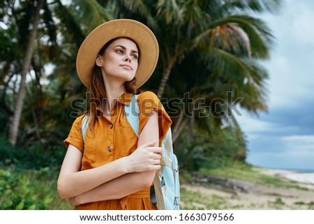 Tropic zodiac palm woman in yellow sundress with backpack on her back
