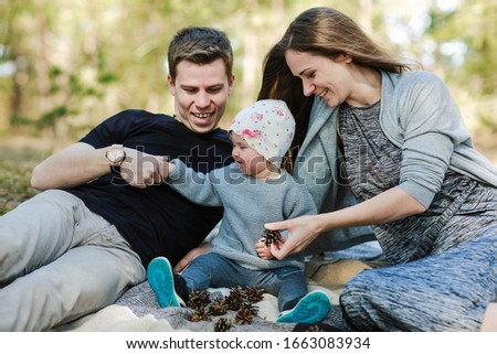 happy family photo in the forest. mom, dad and little girl are having fun in nature. great family happiness. mom without makeup. natural feminine beauty. girl with very long hair