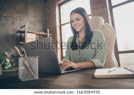 Photo of attractive latin business lady notebook table chatting colleagues read corporate report wear striped shirt sitting chair modern interior office indoors