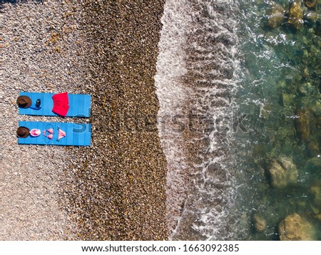 Aerial view. Women's swimsuit and men's beach shorts in a composition with a mask for diving and snorkeling lie on a blue rug by the sea. Leather cowboy hat. vacation is waiting for you
