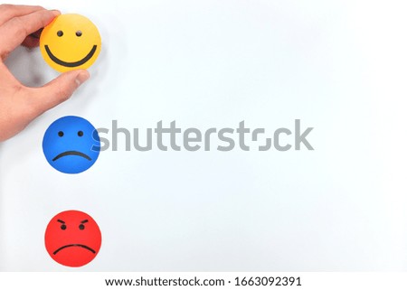 Happy, sad and angry face icons in white background with hand choosing happiness. Customer satisfaction and feedback concept.