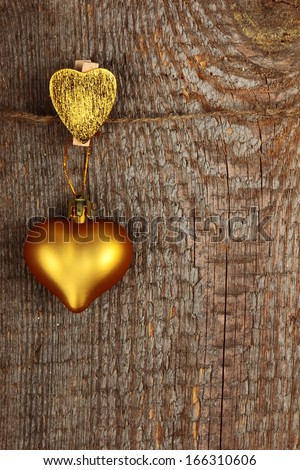Clothes-peg in shape of heart on old wooden background