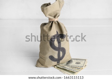 Bag with money and dollar banknotes on white background