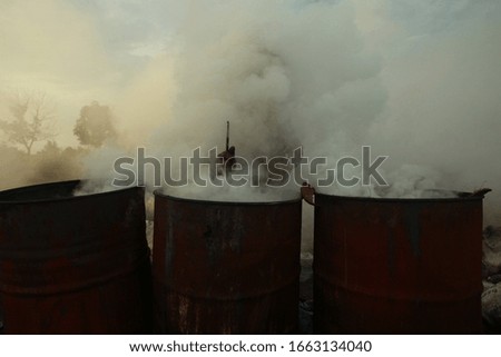 workers wrestle with smoke when burning coconut shells to be used as charcoal in Palembang. Coconut trees are very beneficial for health and industry