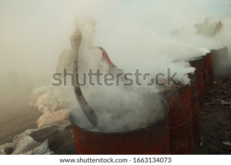 workers wrestle with smoke when burning coconut shells to be used as charcoal in Palembang. Coconut trees are very beneficial for health and industry