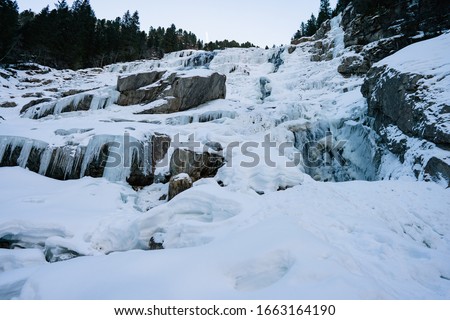 Frozen waterfall with clea blue water at early spring. Grawa Waterfall in Stubaital Valley in Tirol, Austria. Concept winter fun