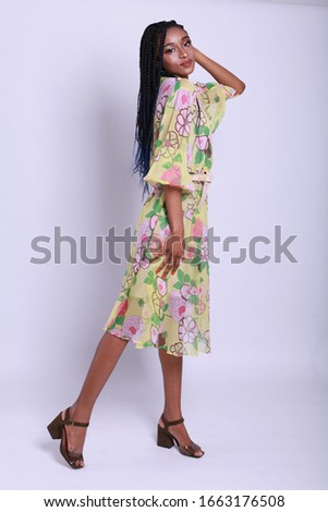 Female beauty concept. Portrait of fashionable young black  girl in romantic colorful silk dress posing over white background. Perfect hair & skin. Vogue style. Studio shot
Studio shot. 