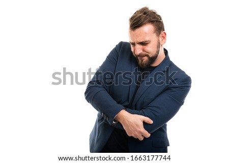 Business man wearing smart casual clothes gesturing elbow ache isolated on white background with copy space advertising area