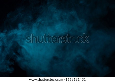 Blue smoke effect on a black background in a studio Royalty-Free Stock Photo #1663181431