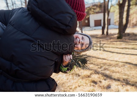 mom hugs a cheerful child in the forest
