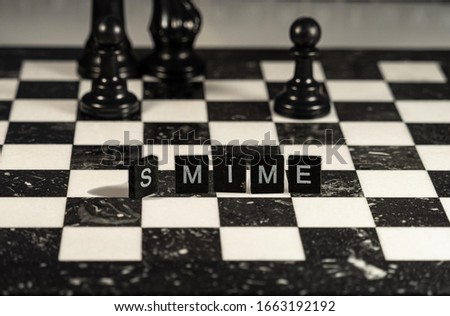 S/MIME public key encryption signing standard for MIME data concept represented by black and white letter tiles on a marble chessboard with chess pieces