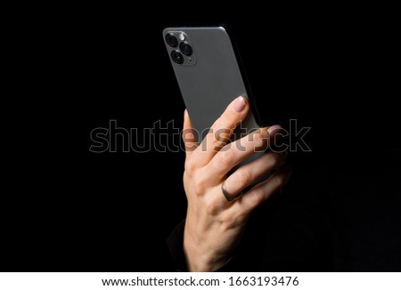Person holding mobile phone, photo isolated on black background
