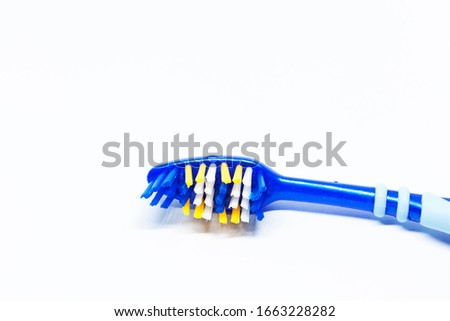 part of a blue toothbrush on white background