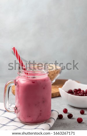 Freshly homemade smoothie with cranberries, oatmeal and yogurt in a mug jar on a gray table. Healthy eating concept. Vertical image with copyspace