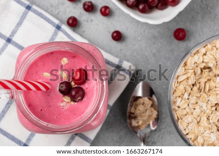 Freshly homemade smoothie with cranberries, oatmeal and yogurt in a mug jar on a gray table. Healthy eating concept. Top view, flatlay