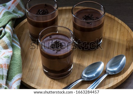 Glass cups of chocolate with two spoons