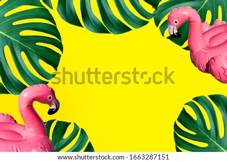 Frame for summer beach concept. Inflatable pink flamingo and tropical leaf monstera on yellow background, pool  party with place for text