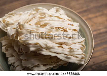 Dry hand-cut noodles （Knife-shaved noodles）on a vintage wood background, Chinese cuisine, Taiwanese cuisine,