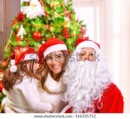 Christmas party, happy family at home celebrating New Year, mother with daughter and Santa claus near Xmas tree, happiness concept