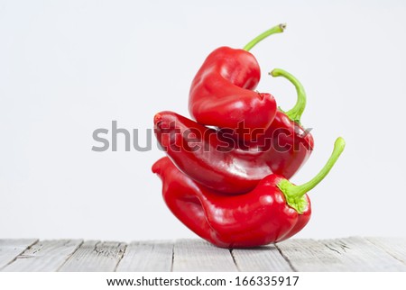 stack of red peppers on old wooden table