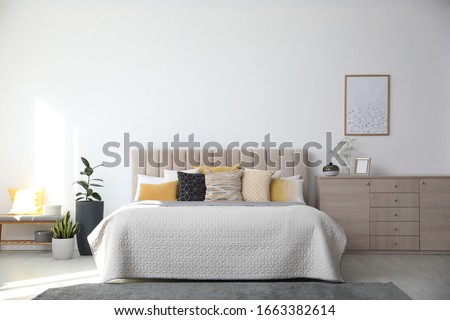 Stylish interior of contemporary room with comfortable bed Royalty-Free Stock Photo #1663382614