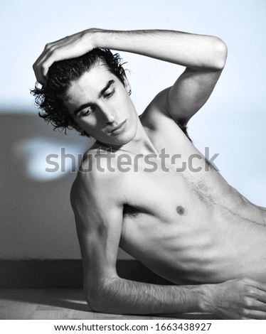 black and white portrait photography. expressive mediterranean Italian dark haired handsome male model boy with angel face and fit sportive body posing for casual fashion shooting