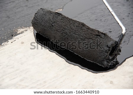 roller brush on concrete. Waterproofing coating. Copy space. Space for text.  closeup. Tools. Royalty-Free Stock Photo #1663440910