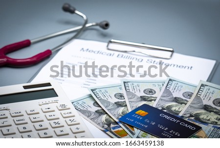 top view picture of medical billing statement, cradit card,  calculator, banknotes and pink stethoscope on the gray background