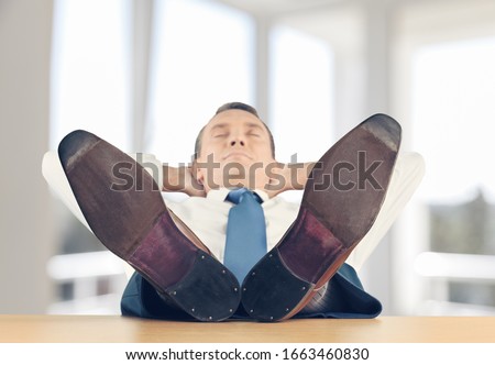 Satisfied businessman in the comfortable office chair during break