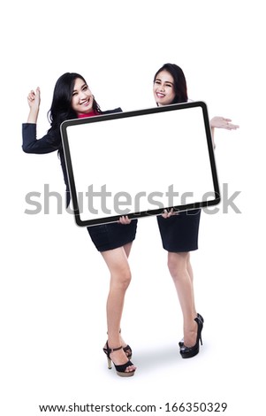 Two business women showing an empty board isolated on white background