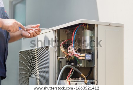 Male technician hands using a screwdriver fixing modern air conditioner, repairing and servicing, Maintenance and repairing concept
 Royalty-Free Stock Photo #1663521412