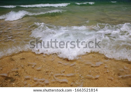 A picture of white wave, clear sea, yellow sand in natural daylight from Thailand.