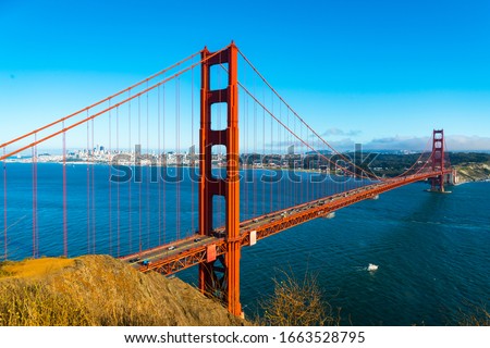 boat going under gorgeous national monument and landmark suspension bridge overlooking San Francisco at the Golden gate bridge