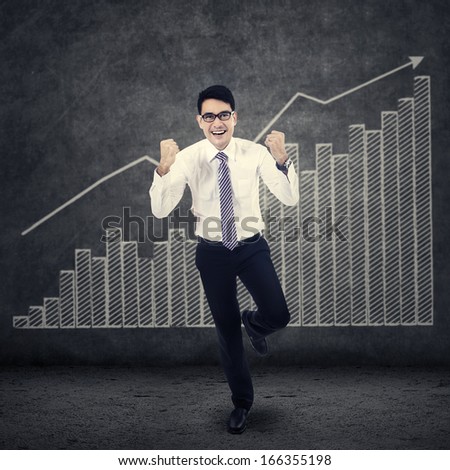 Successful businessman and financial graph on the wall