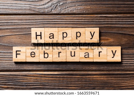 Happy February word written on wood block. Happy February text on table, concept.