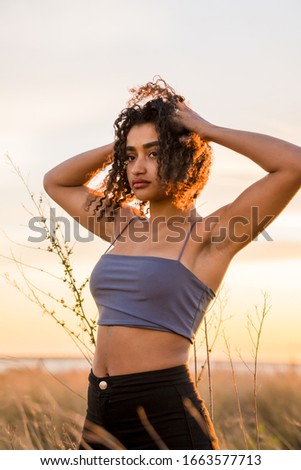 Young black girl posing with the beach in the background, vertical image