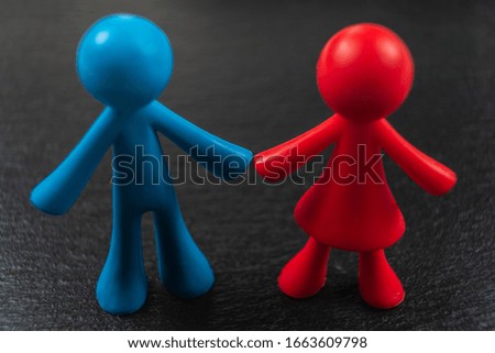 Small red and blue plastic toy copleFigurines of an couple.Selected focus.